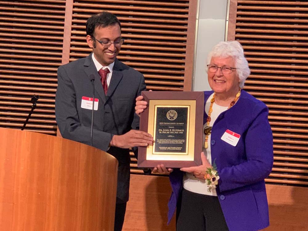 Ankur Desai presents the Outstanding Achievement Alumni Award to Gisela Kutzbach